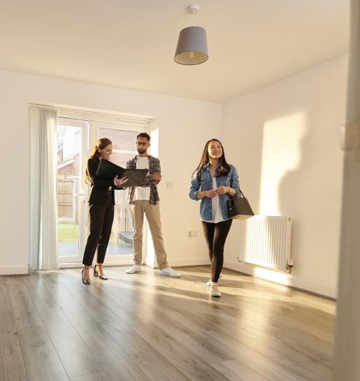 A young couple looking at a home with their real estate agent.