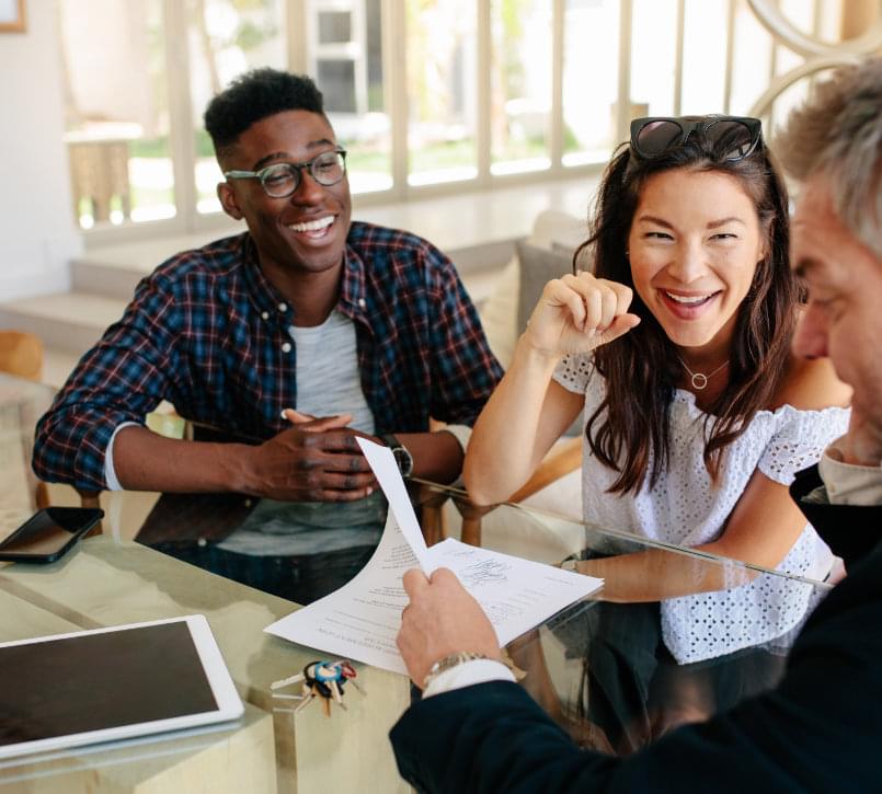 A couple shaking hands with their real estate agent.