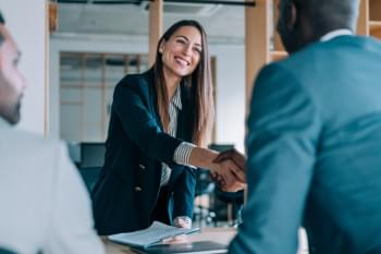 Real estate agent shaking hands with client.